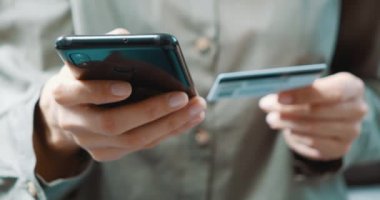Akıllı telefon ve kredi kartı tutan ve evde online alışveriş yapan kadınları kapatın. Bankacılık, çevrimiçi alışveriş ve yaşam tarzı kavramı.