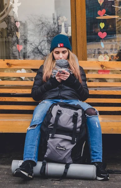 Kız bir banch üzerinde oturan ve bir telefon kullanma