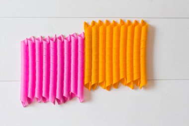 Magic leverag curlers. Pembe ve turuncu saç curlers hafif ahşap zemin üzerine