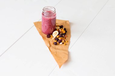 Kurutulmuş kiraz, muz, elma, yaban mersini bir highball cam beyaz zemin üzerine güler yüzlü. Kurutulmuş meyve güler yüzlü