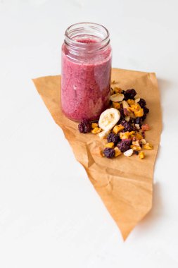 Kurutulmuş kiraz, muz, elma, yaban mersini bir highball cam beyaz zemin üzerine güler yüzlü. Kurutulmuş meyve güler yüzlü