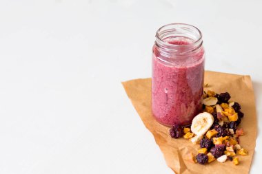 Kurutulmuş kiraz, muz, elma, yaban mersini bir highball cam beyaz zemin üzerine güler yüzlü. Kurutulmuş meyve güler yüzlü