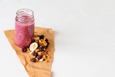 Kurutulmuş kiraz, muz, elma, yaban mersini bir highball cam beyaz zemin üzerine güler yüzlü. Kurutulmuş meyve güler yüzlü