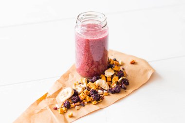 Kurutulmuş kiraz, muz, elma, yaban mersini bir highball cam beyaz zemin üzerine güler yüzlü. Kurutulmuş meyve güler yüzlü