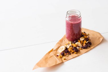 Kurutulmuş kiraz, muz, elma, yaban mersini bir highball cam beyaz zemin üzerine güler yüzlü. Kurutulmuş meyve güler yüzlü