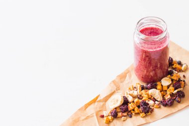 Kurutulmuş kiraz, muz, elma, yaban mersini bir highball cam beyaz zemin üzerine güler yüzlü. Kurutulmuş meyve güler yüzlü