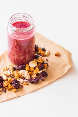 Kurutulmuş kiraz, muz, elma, yaban mersini bir highball cam beyaz zemin üzerine güler yüzlü. Kurutulmuş meyve güler yüzlü