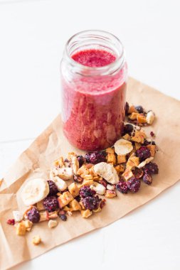 Kurutulmuş kiraz, muz, elma, yaban mersini bir highball cam beyaz zemin üzerine güler yüzlü. Kurutulmuş meyve güler yüzlü