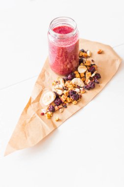 Kurutulmuş kiraz, muz, elma, yaban mersini bir highball cam beyaz zemin üzerine güler yüzlü. Kurutulmuş meyve güler yüzlü