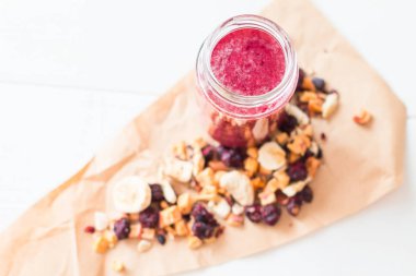 Kurutulmuş kiraz, muz, elma, yaban mersini bir highball cam beyaz zemin üzerine güler yüzlü. Kurutulmuş meyve güler yüzlü