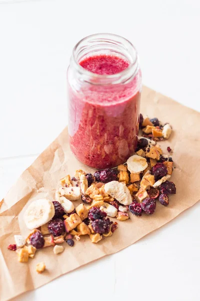 Kurutulmuş kiraz, muz, elma, yaban mersini bir highball cam beyaz zemin üzerine güler yüzlü. Kurutulmuş meyve güler yüzlü