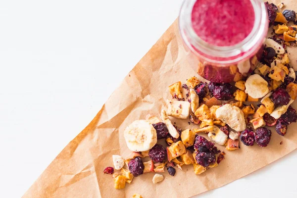 Kurutulmuş kiraz, muz, elma, yaban mersini bir highball cam beyaz zemin üzerine güler yüzlü. Kurutulmuş meyve güler yüzlü