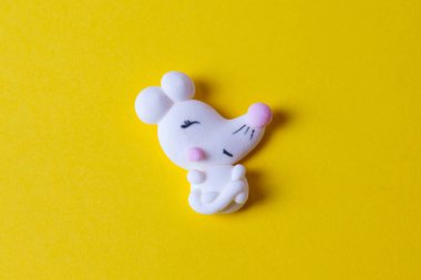 Marshmallow 'u beyaz fare ya da fare şeklinde kapatın ve sarı arka planda izole edin. Yeni yıl ve Noel 2020 konsepti. Beyaz fare ya da fare şekerlemesi - 2020 yılının sembolü