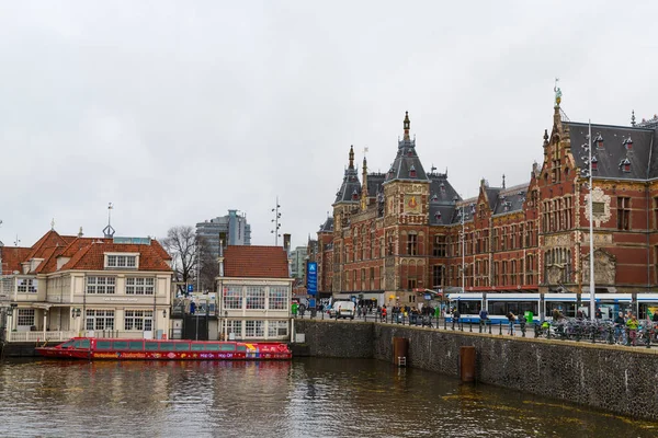 Amsterdam, Paesi Bassi - 28 novembre 2019: Amsterdam Central station. Molte biciclette parcheggiate di fronte alla stazione centrale. Barche turistiche . — Foto Stock