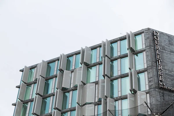 Ámsterdam, Países Bajos - 28 de noviembre de 2019: DoubleTree by Hilton Hotels Architecture. Vista panorámica del nuevo edificio gris moderno contra el cielo azul —  Fotos de Stock