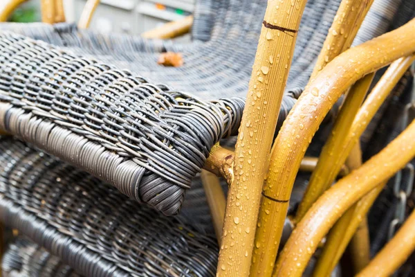 Chaises d'extérieur en osier après la pluie avec gouttes de pluie Photo De Stock