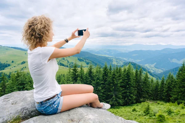 Vrouw wandelaar nemen foto met mobiele telefoon op de bergtop — Stockfoto