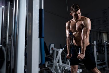 adam çıplak bir gövde ile spor salonunda bir triceps trenler