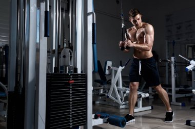 adam çıplak bir gövde ile spor salonunda bir triceps trenler