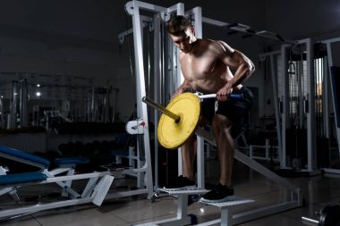 adam bir spor salonunda deadlift yapıyor çıplak bir gövde ile