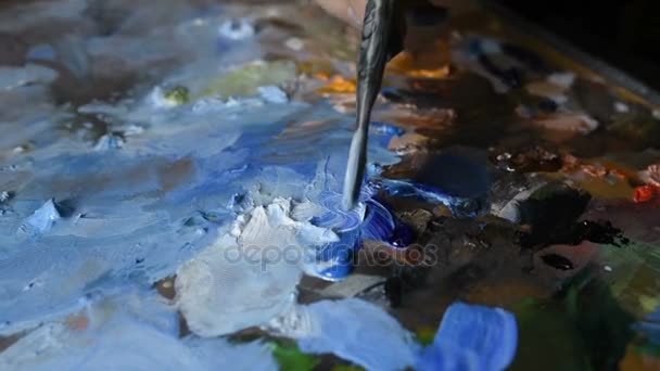 Kunstenaar mengt olie verf met een borstel op het palet — Stockvideo