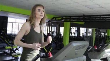 Atletik kız bir koşu bandı üzerinde çalışan