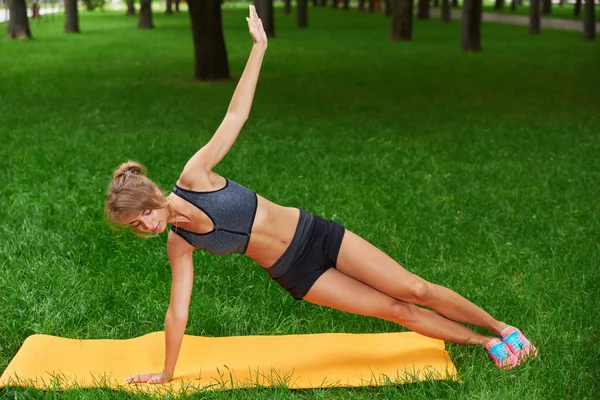 Девушка занимается фитнесом и гимнастикой в парке — стоковое фото