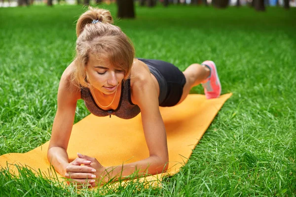Девушка занимается фитнесом и гимнастикой в парке — стоковое фото
