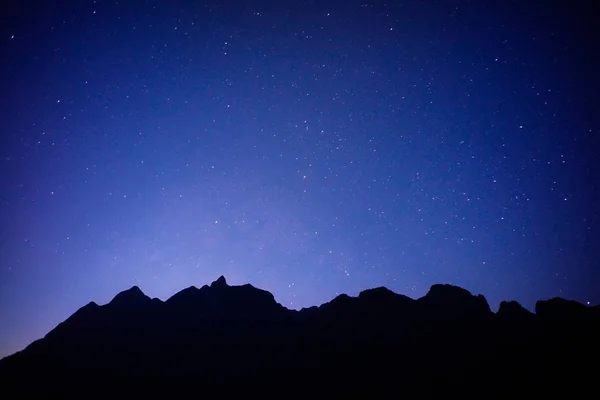 black mountain with full stars in the sky