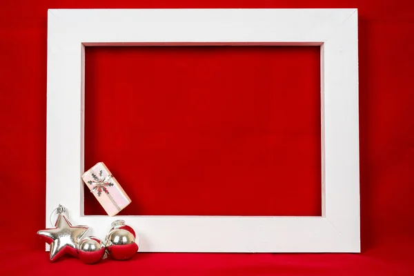 Fehér fából készült test és egy karácsonyi ajándék, mint egy piros háttér — Stock Fotó