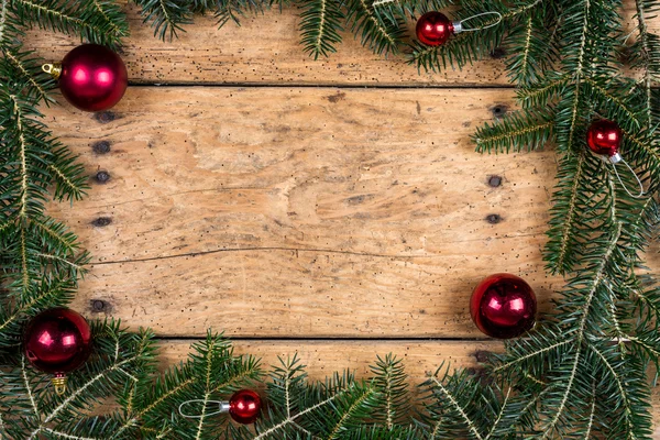 Christmas frame of fir branches over vintage wood — Stock Photo, Image