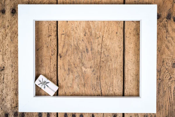 Christmas background - white wooden frame and a gift over a vintage wood- copy space — Stock Photo, Image