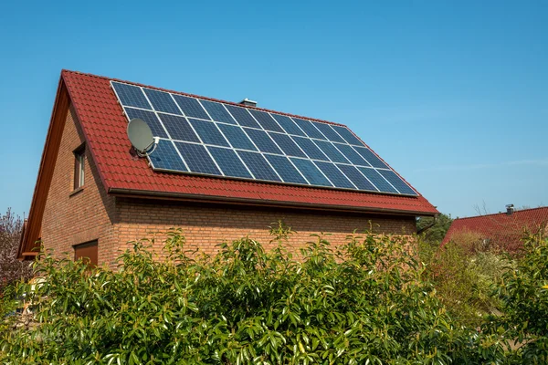 赤い屋根の上の太陽電池パネル — ストック写真