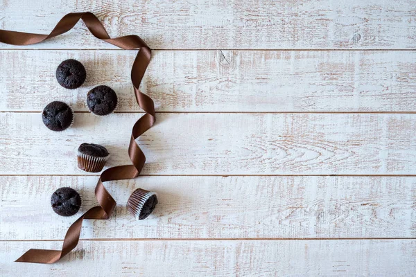 Muffins de chocolate em uma mesa de madeira rústica branca foco seletivo, espaço de cópia — Fotografia de Stock