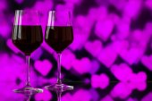 Dvě sklenice červeného vína proti bokeh na pozadí s jiskří