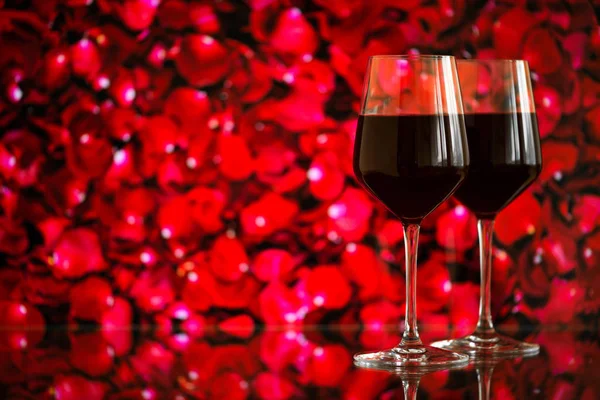 Due bicchieri di vino rosso sullo sfondo bokeh con scintille e rose. Profondità di campo molto bassa. Focus selettivo, spazio di copia — Foto Stock