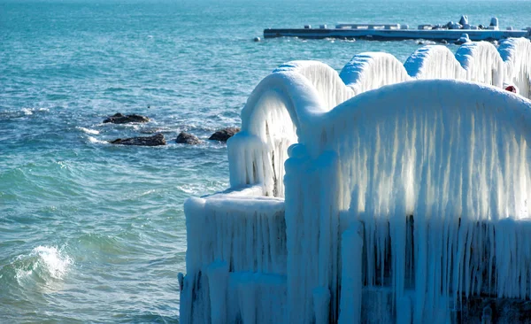 Icicles πάνω από τις καμάρες του εγκαταλελειμμένα πισίνα δίπλα στη θάλασσα — Φωτογραφία Αρχείου