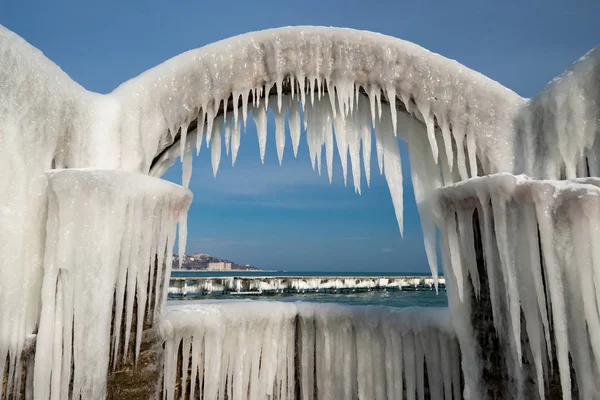 Icicles πάνω από τις καμάρες του εγκαταλελειμμένα πισίνα δίπλα στη θάλασσα — Φωτογραφία Αρχείου