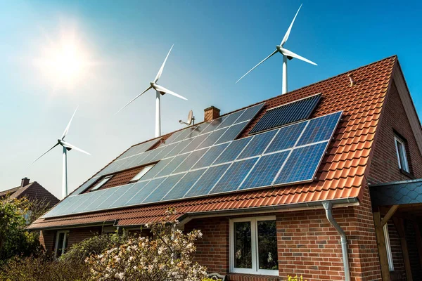 Sonnenkollektor auf dem Dach eines Hauses und umliegende Windkraftanlagen - Konzept nachhaltiger Ressourcen — Stockfoto