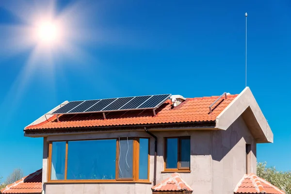 Zonnepaneel op een rood dak - bron van alternatieve elektriciteit — Stockfoto