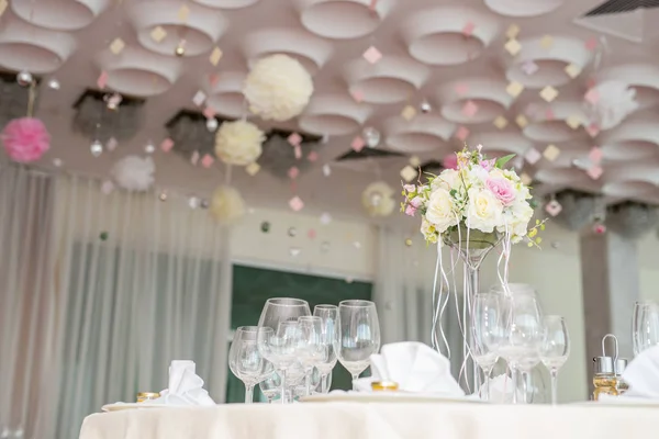 Krásná svatební květinové dekorace na stůl v restauraci. Bílé ubrusy, světlý pokoj. — Stock fotografie