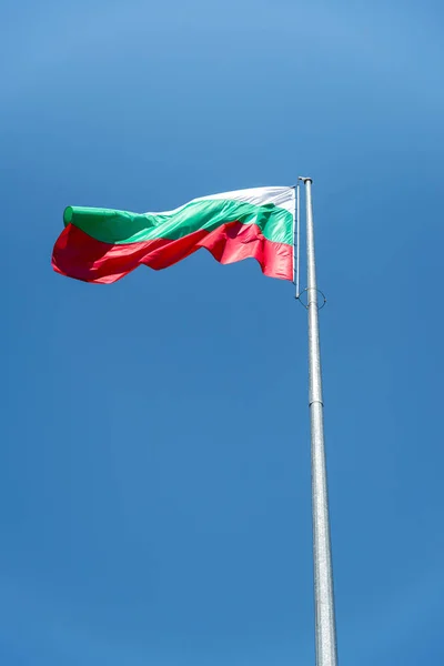 De Bulgaarse nationale vlag zwaaien hoog in de hemel — Stockfoto