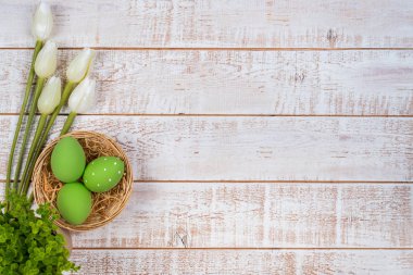 Renkli Paskalya yumurtaları ve Lale Beyaz ahşap masa üzerinde