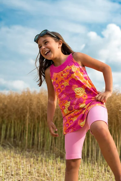 快乐的小女孩在成熟的油菜籽-垂直方向的领域 — 图库照片