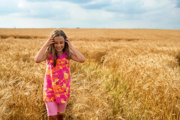 Happy little girl in a field of ripe wheat — Stock Photo, Image