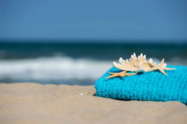 Summer vacation concept  towel with sunglasses and starfish on sandy tropical beach - selective focus, copy space — Stock Photo, Image