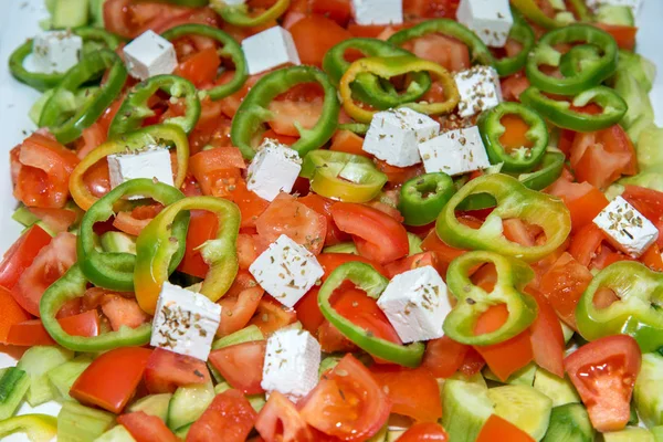 Nahaufnahme eines Salats aus Tomaten, Gurken, Paprika und Käse mit Gewürzen — Stockfoto