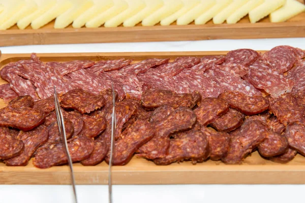 Restauration de l'événement - différents types de spécialités de viande et de fromage disposées dans une assiette en bois sur fond blanc - accent sélectif — Photo