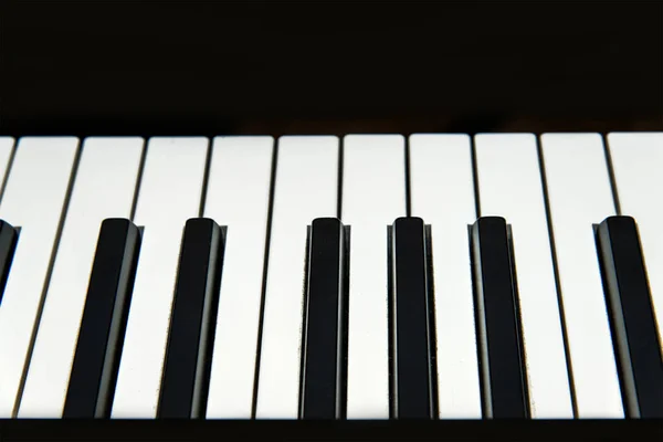 Teclado para piano y piano con fondos negros. Espacio para texto . — Foto de Stock