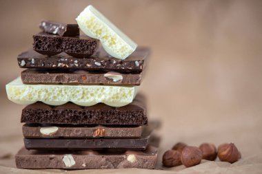 Fındık kakao tozu ve nane içeren farklı çikolata çeşitleri. Seçici odak, kahverengi kağıt kaplama arka plan.